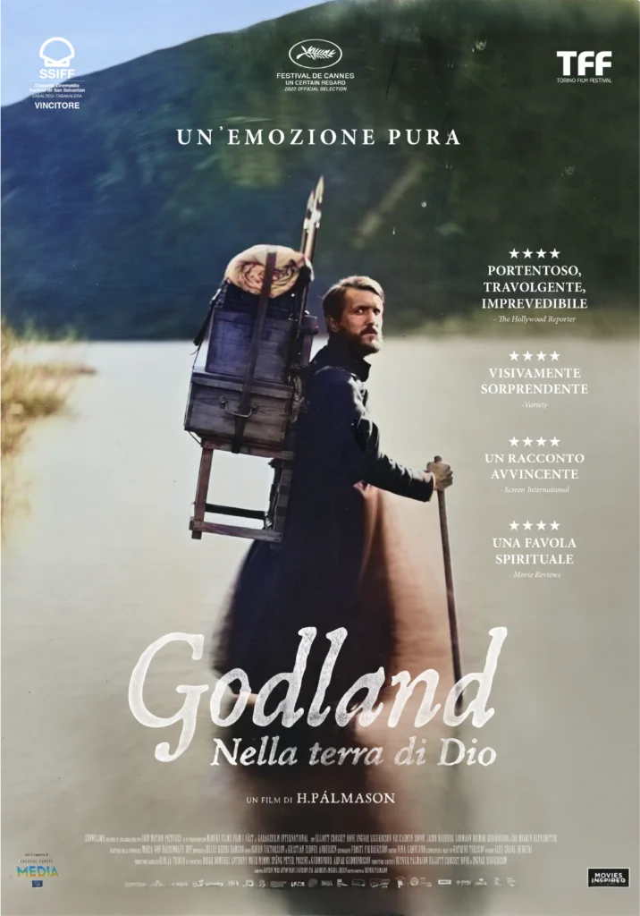 Locandina ufficiale del film Godland - Nella terra di Dio, con l’immagine del protagonista che trasporta una sedia su uno sfondo naturale e critiche entusiastiche.